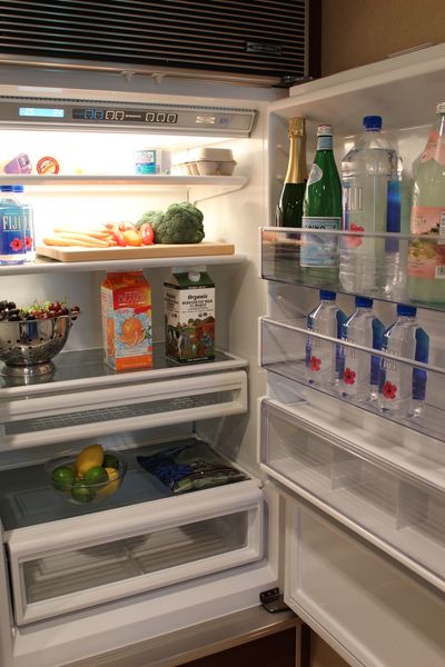Interior of a refrigerator, lined with beverages and fresh snacks